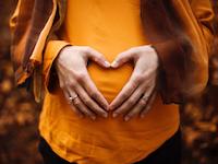 Woman with hands in front of the baby bump